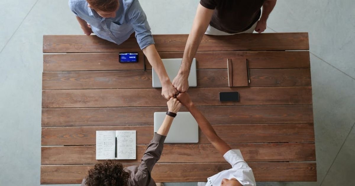 Diverse-People-Fist-Bumping-Over-Table